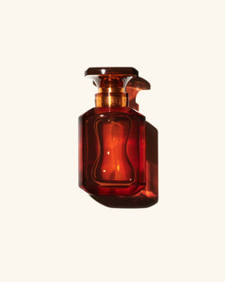 Fenty Eau de Parfum clear chestnut brown tinted glass perfume bottle on beige background Fenty Eau de Parfum clear chestnut brown tinted glass perfume bottle on beige background