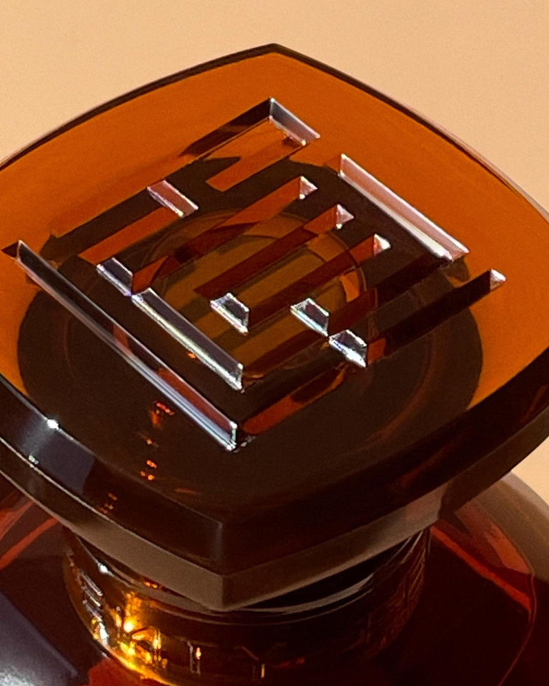 close up photo of Fenty Eau de Parfum clear chestnut brown tinted glass perfume bottle cap