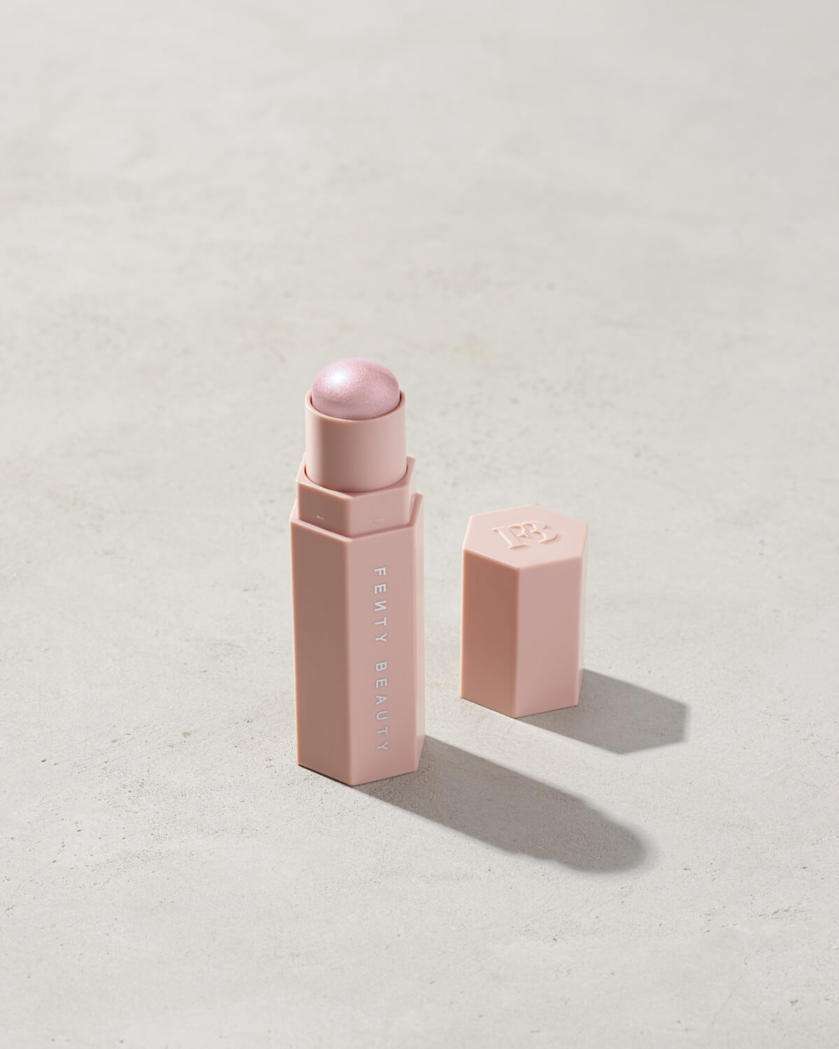 Match Stix Shimmer Skinstick shown in shade Confetti on a concrete background.