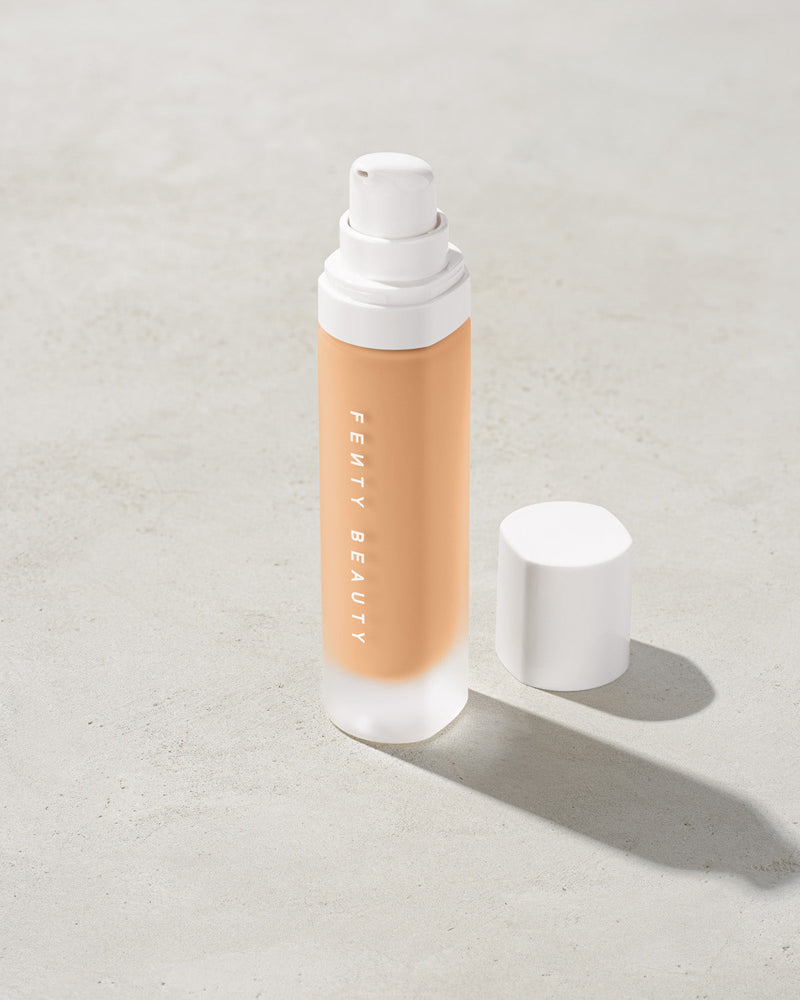 open bottle of Fenty Beauty Pro Filt'r Soft Matte Longwear Foundation with pump dispenser in shade #220 on concrete background