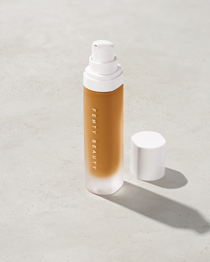 open bottle of Fenty Beauty Pro Filt'r Soft Matte Longwear Foundation with pump dispenser in shade 350 on concrete background