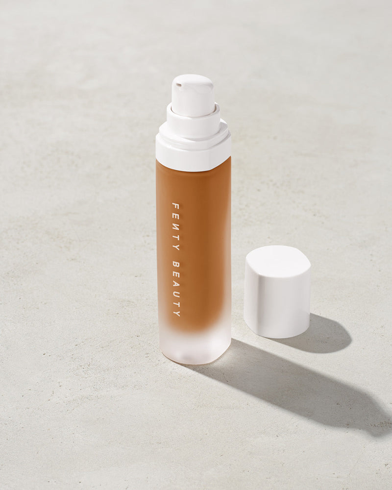open bottle of Fenty Beauty Pro Filt'r Soft Matte Longwear Foundation with pump dispenser in shade 410 on concrete background
