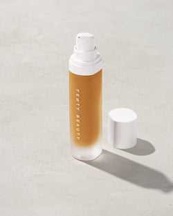 open bottle of Fenty Beauty Pro Filt'r Soft Matte Longwear Foundation with pump dispenser in shade 420 on concrete background open bottle of Fenty Beauty Pro Filt'r Soft Matte Longwear Foundation with pump dispenser in shade 420 on concrete background