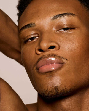 medium skin toned model wearing gloss bomb universal lip luminizer in Fenty Glow