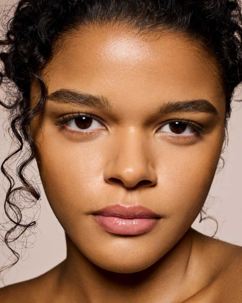 medium skin toned model wearing gloss bomb universal lip luminizer in shade Glass Slipper