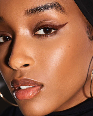 model with winged eyeliner look using Fenty Beauty Flyliner Longwear Liquid Eyeliner in shade In Big Truffle