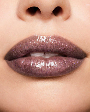 Macro shot of model wearing Fenty Beauty Gloss Bomb Universal Lip Luminizer in shade Kaboom.
