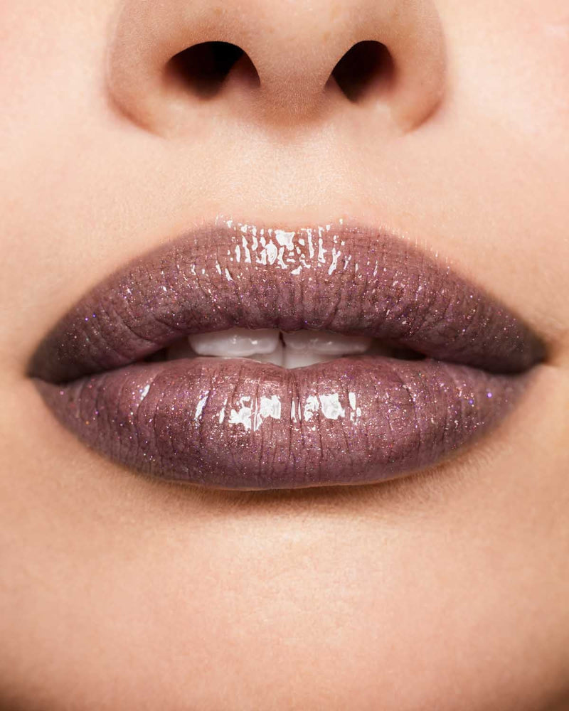 Macro shot of model wearing Fenty Beauty Gloss Bomb Universal Lip Luminizer in shade Kaboom.