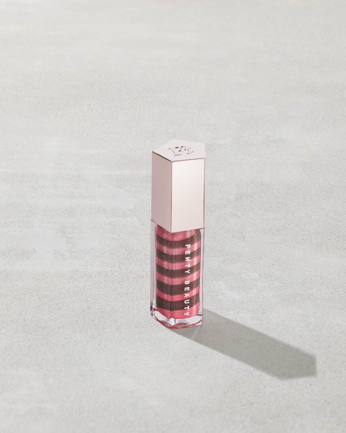Lip gloss with a silver cap on a light gray background