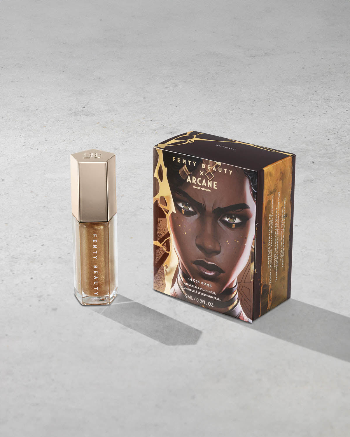 Product shot of Fenty Beauty Gloss Bomb Universal Lip Luminizer and packaging in limited edition Arcane collection shade Risky Ruling.