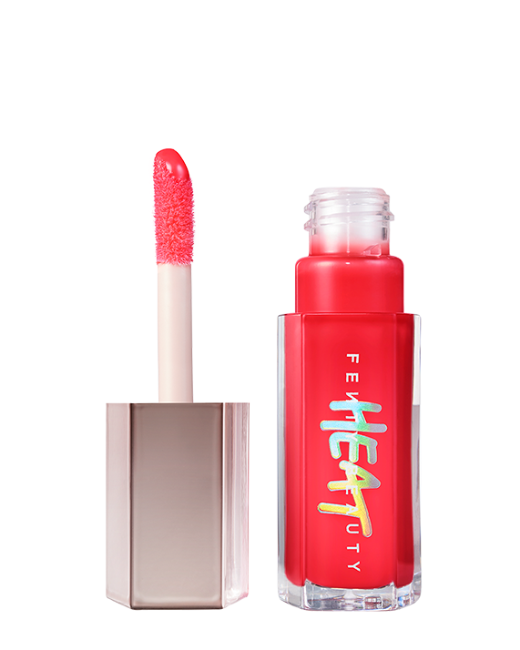 Closed tube of Gloss Bomb Heat lip gloss and plumper in the shade Hot Cherry on a grey background. Closed tube of Gloss Bomb Heat lip gloss and plumper in the shade Hot Cherry on a grey background.