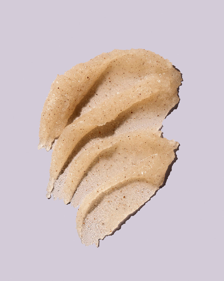 Fenty Skin by Rihanna Buff Ryder Exfoliating Body Scrub smeared on lavender background