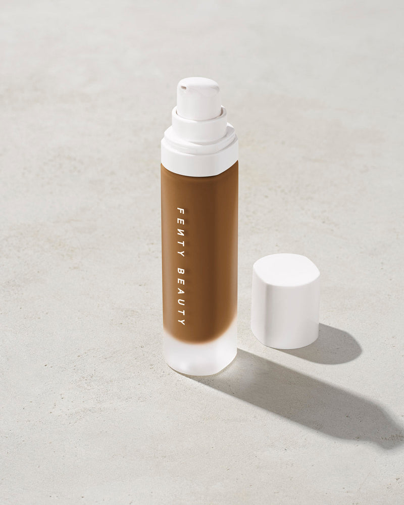 open bottle of Fenty Beauty Pro Filt'r Soft Matte Longwear Foundation with pump dispenser in shade 445 on concrete background