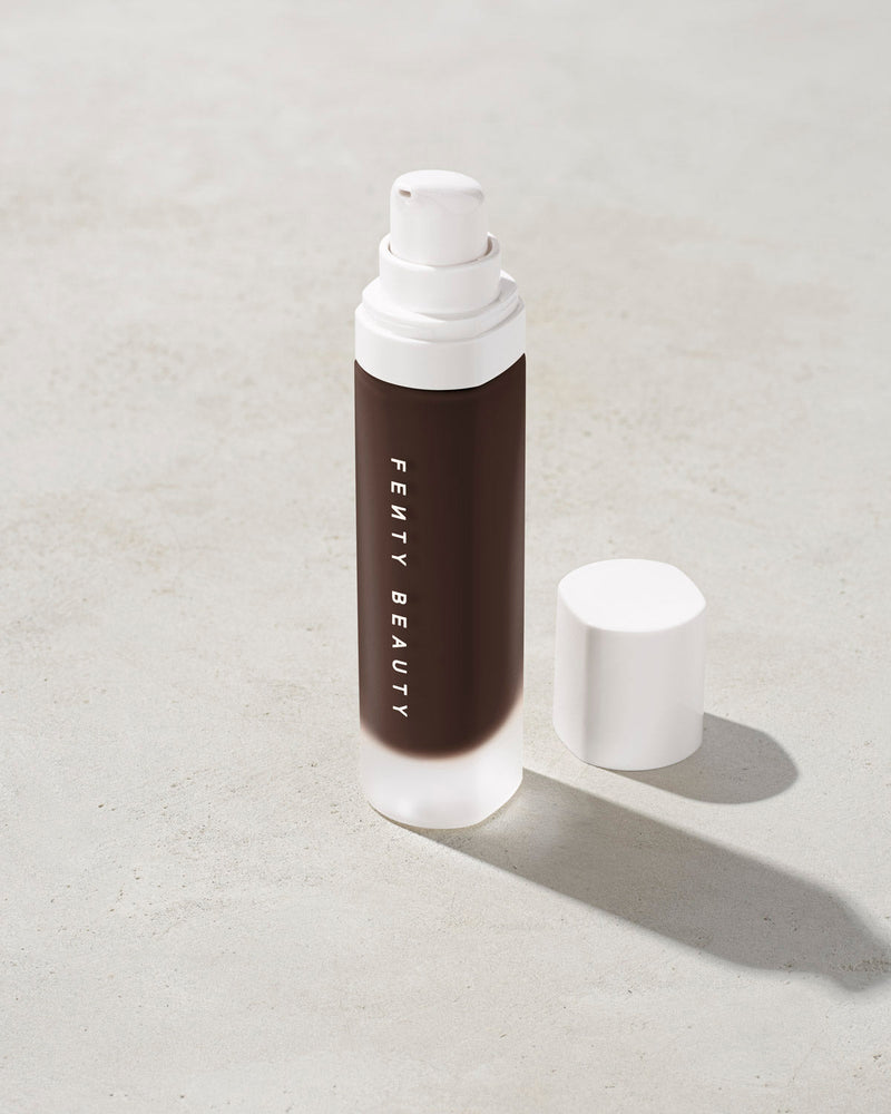 open bottle of Fenty Beauty Pro Filt'r Soft Matte Longwear Foundation with pump dispenser in shade 498 on concrete background