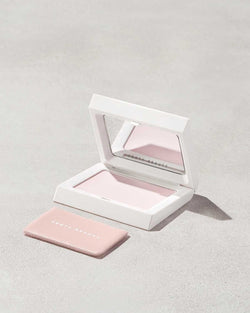 Invisimatte Instant Setting + Blotting Powder with open packaging and blotting cushion shown on a concrete background.