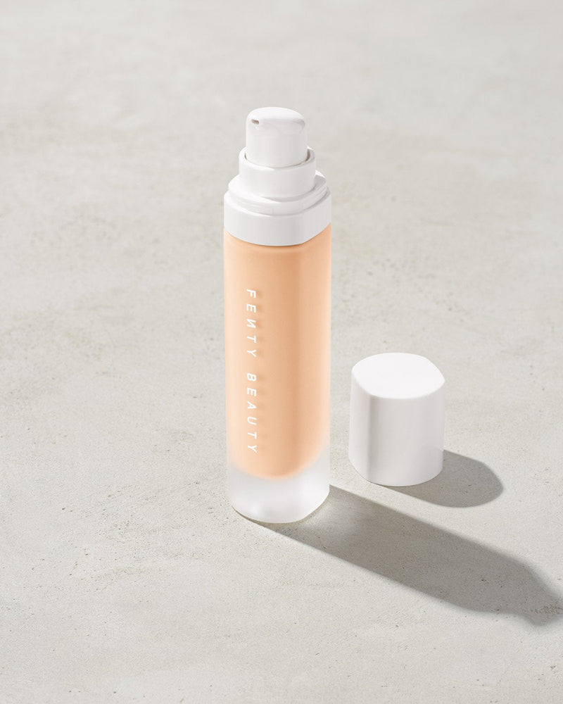 open bottle of Fenty Beauty Pro Filt'r Soft Matte Longwear Foundation with pump dispenser in shade #110 on concrete background
