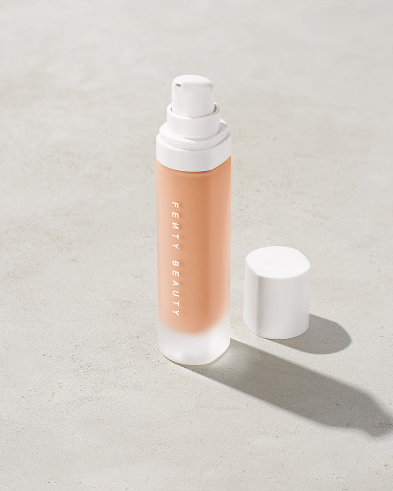 open bottle of Fenty Beauty Pro Filt'r Soft Matte Longwear Foundation with pump dispenser in shade #160 on concrete background
