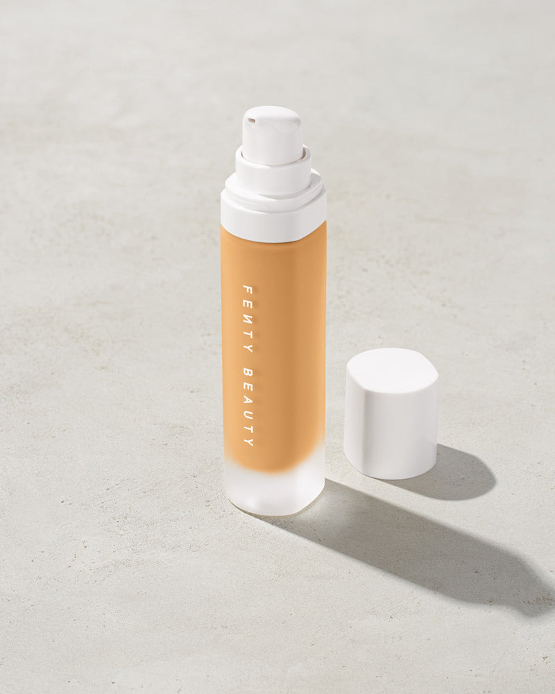 open bottle of Fenty Beauty Pro Filt'r Soft Matte Longwear Foundation with pump dispenser in shade #250 on concrete background