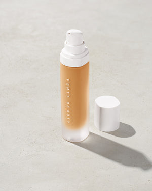 open bottle of Fenty Beauty Pro Filt'r Soft Matte Longwear Foundation with pump dispenser in shade 300 on concrete background