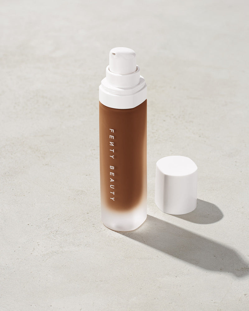 open bottle of Fenty Beauty Pro Filt'r Soft Matte Longwear Foundation with pump dispenser in shade 480 on concrete background