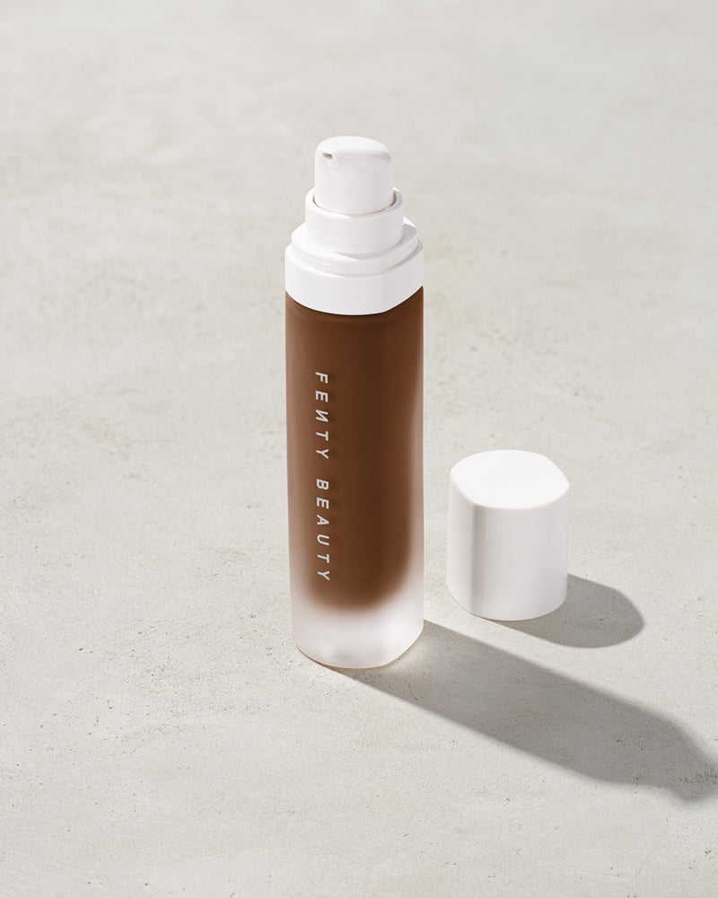 open bottle of Fenty Beauty Pro Filt'r Soft Matte Longwear Foundation with pump dispenser in shade 490 on concrete background