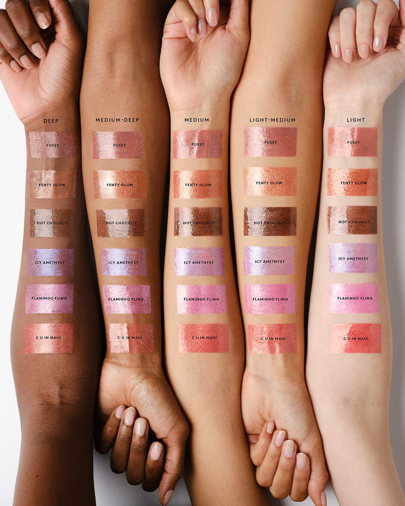 Arm swatch of Gloss Bomb Stix Shimmer High-Shine Gloss Stick line against Deep, Medium Deep, Medium, Medium-Light, and Light skin tones.