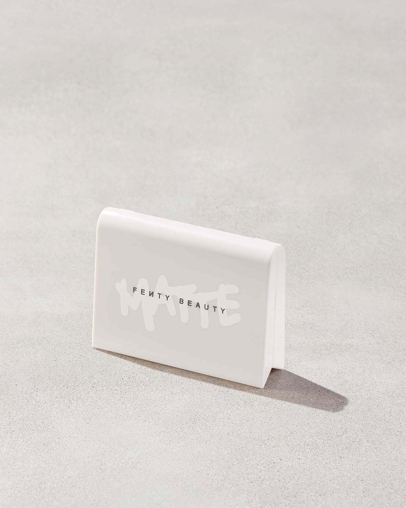 Invisimatte Instant Setting + Blotting Powder with closed packaging shown on a concrete background.