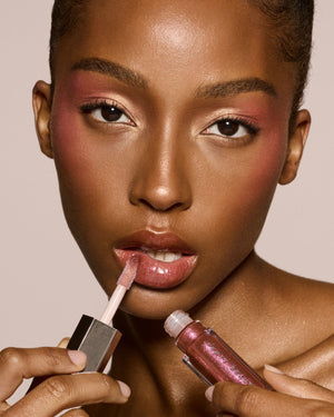 deep skin toned model wearing gloss bomb universal lip luminizer in shade Hot Chocolit