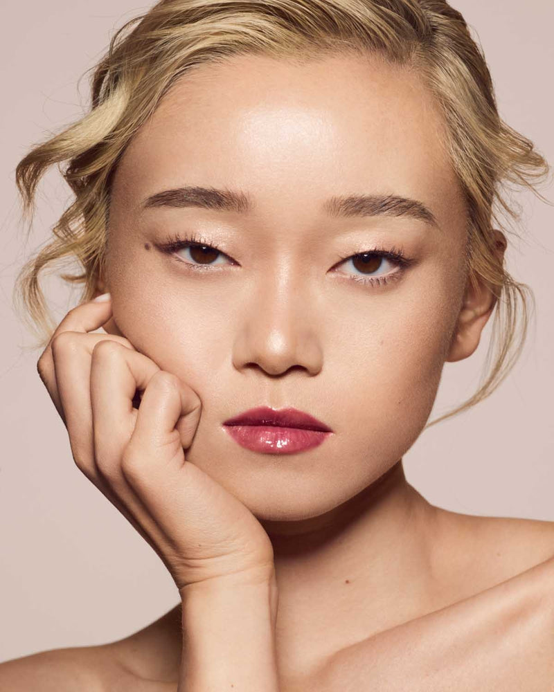 light skin toned model wearing gloss bomb universal lip luminizer in shade RiRi