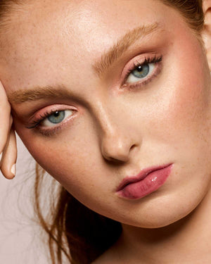 light skin toned model wearing gloss bomb universal lip luminizer in shade RiRi