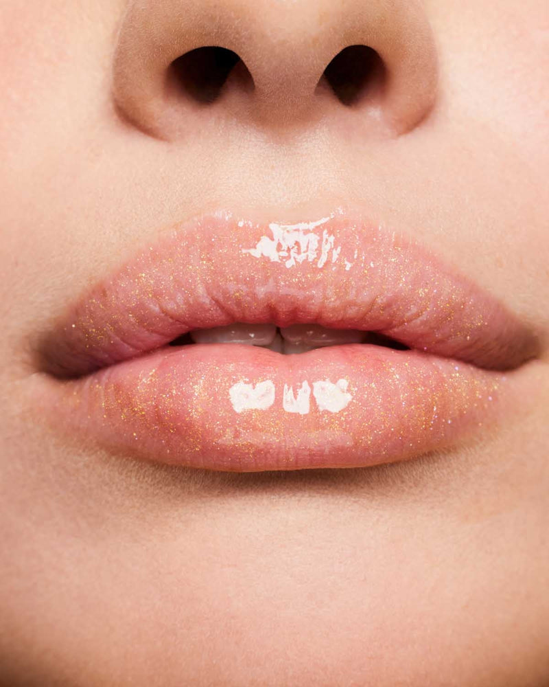 Product shot of Fenty Beauty Gloss Bomb Universal Lip Luminizer and packaging in limited edition Arcane collection shade Risky Ruling.