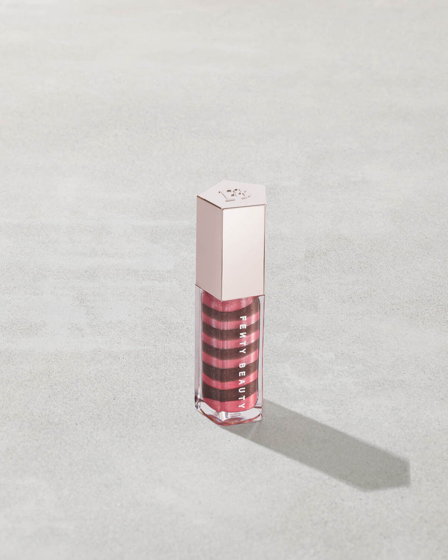 Lip gloss with a silver cap on a light gray background