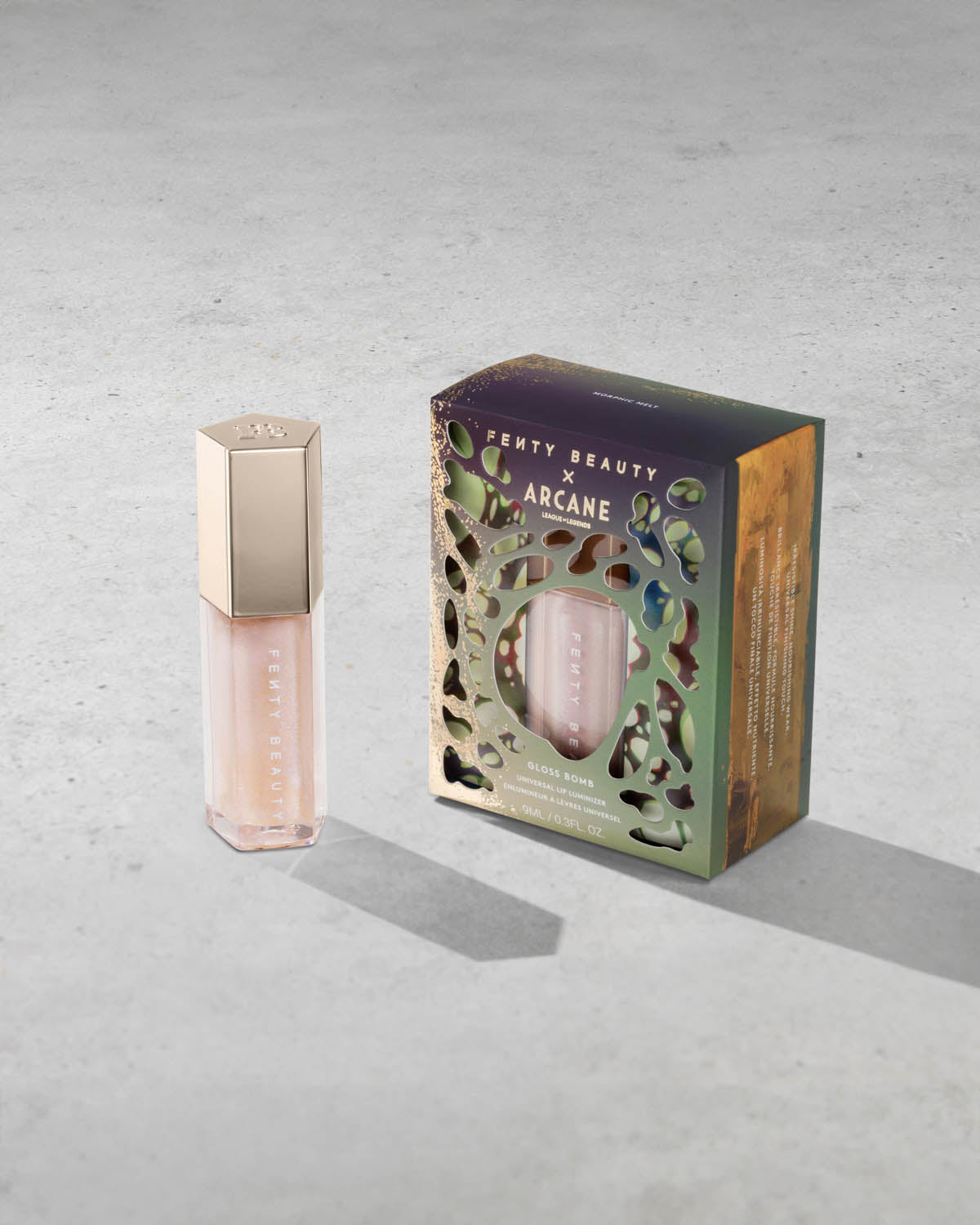Product shot of Fenty Beauty Gloss Bomb Universal Lip Luminizer and packaging in limited edition Arcane collection shade Morphic Melt. 