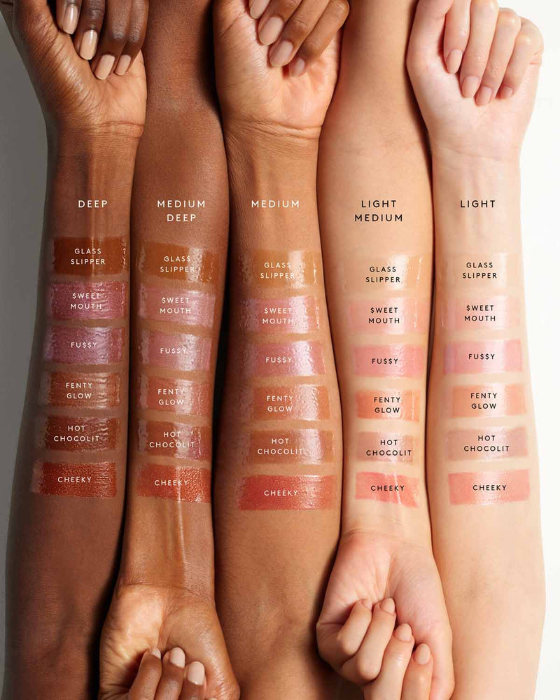 Side-by-side of five models' arms showing the six shades of Gloss Bomb Heat lip gloss on different skin tones.