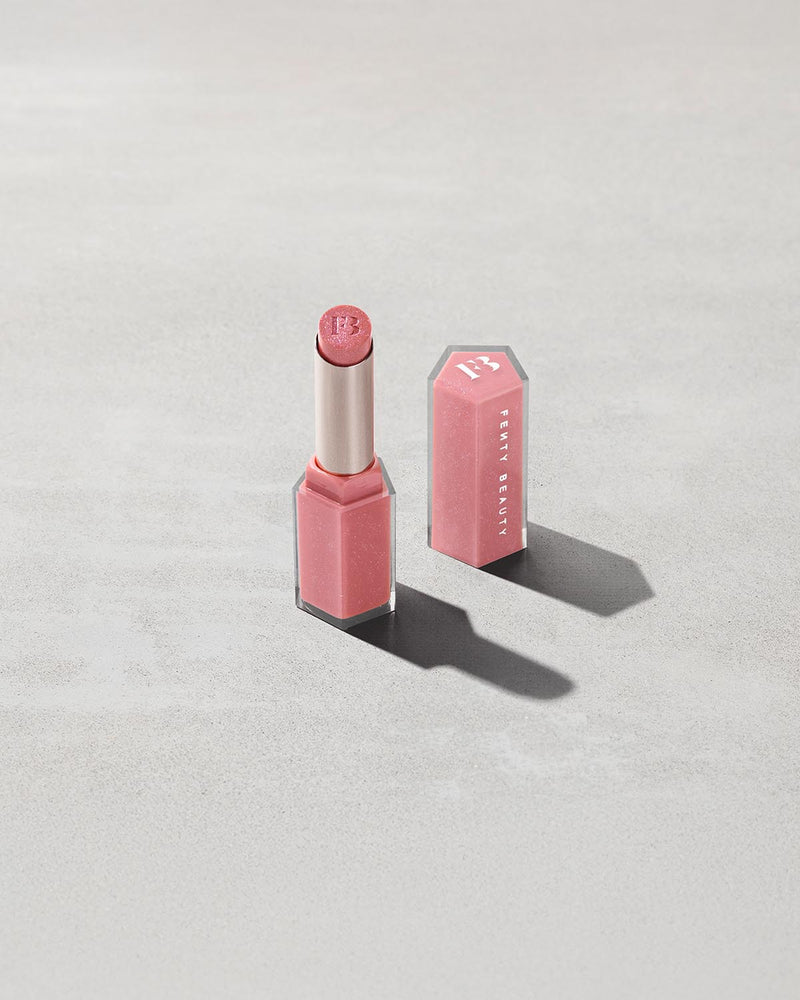 Open product shot of Gloss Bomb Stix Shimmer in shade Fussy on a concrete background.