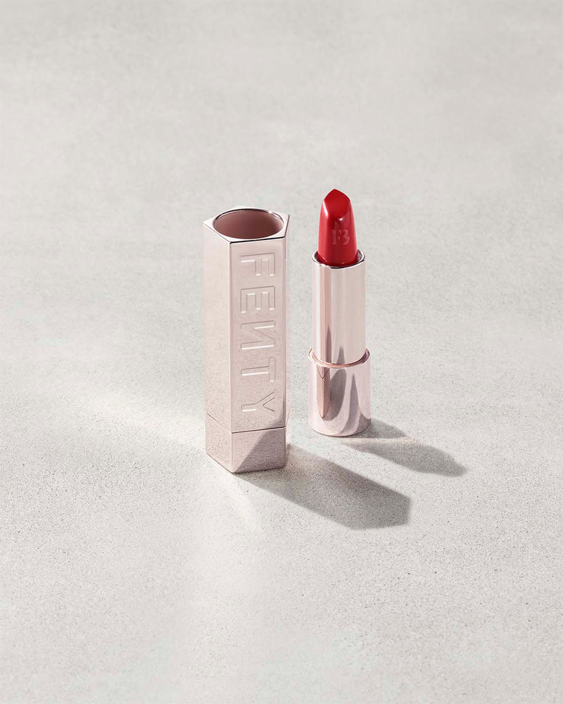 Fenty Icon lipstick shade in The MVP, next to a metallic lipstick case.
