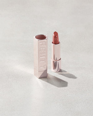 Fenty Icon lipstick shade in Ballin' Babe, next to a metallic lipstick case.