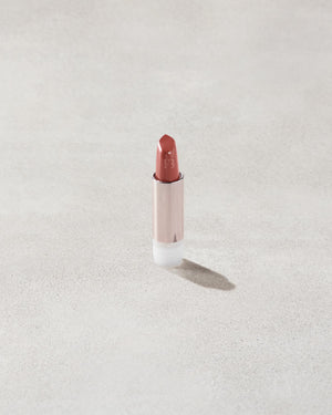 An open Fenty Icon refillable matte lipstick in the high-pigment shade, Ballin' Babe.
