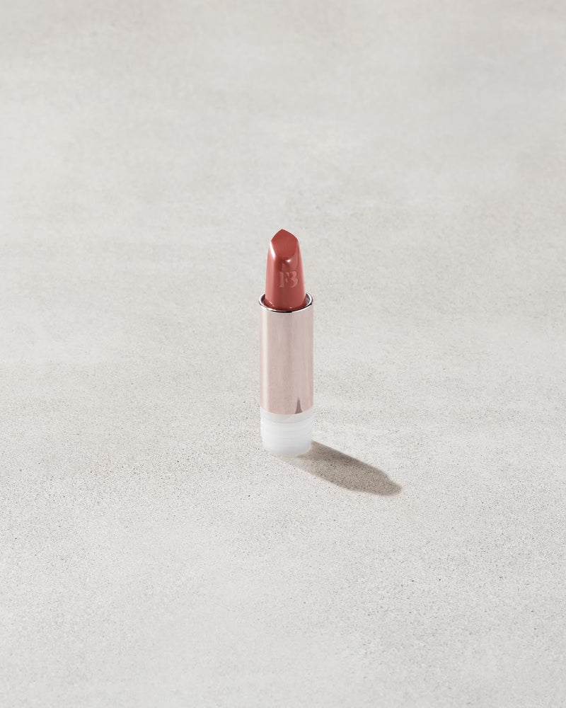 An open Fenty Icon refillable matte lipstick in the high-pigment shade, Ballin' Babe.