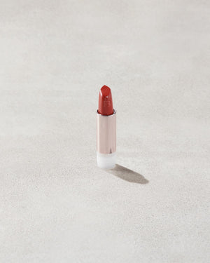 An open Fenty Icon refillable matte lipstick in the high-pigment shade, Grill Mast'r.