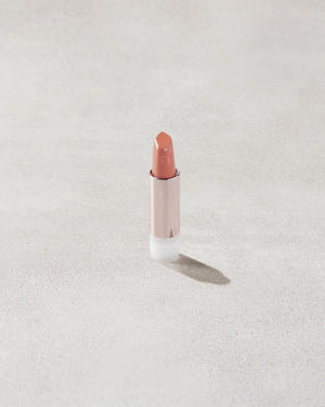 An open Fenty Icon refillable matte lipstick in the high-pigment shade, Pose Queen.