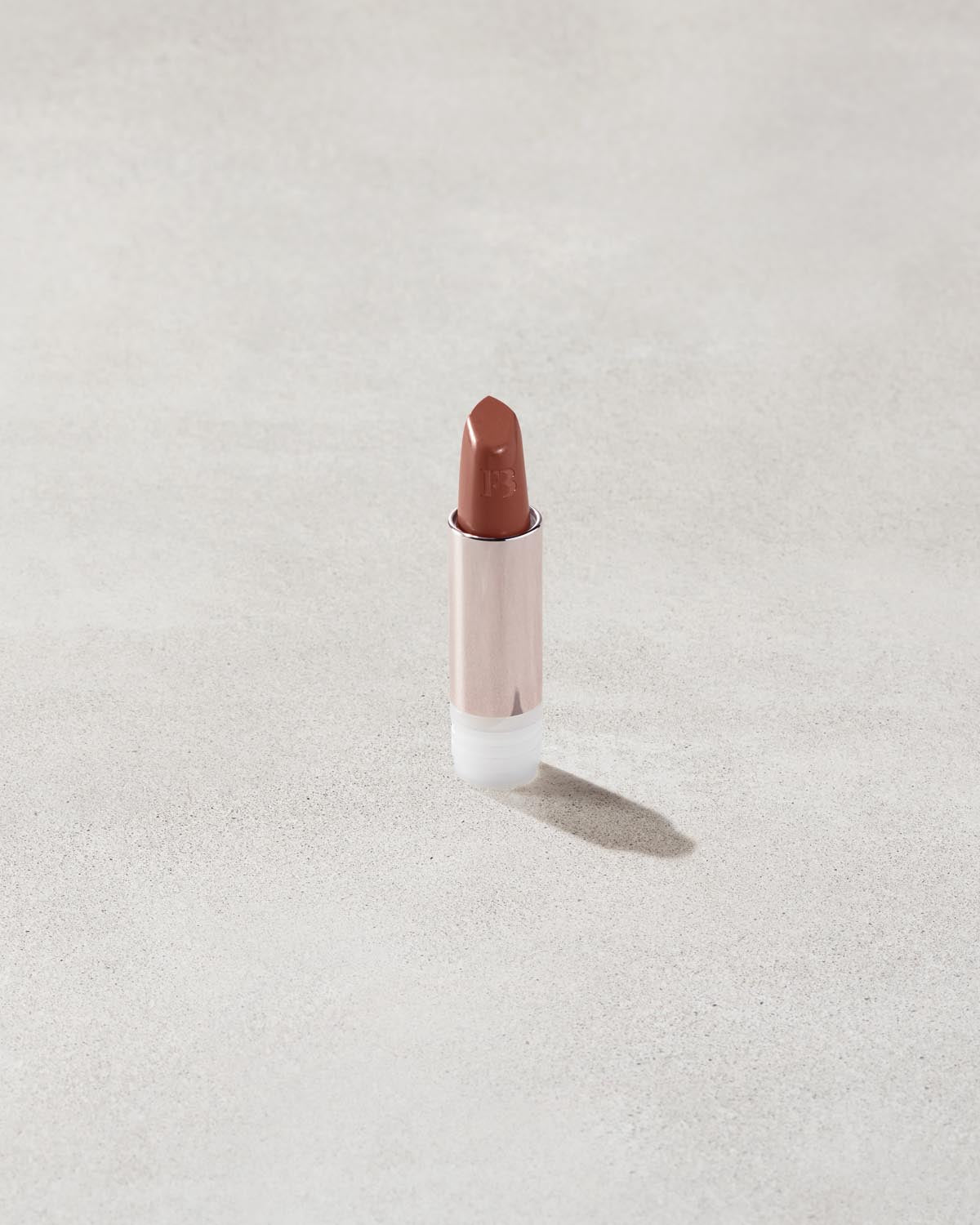 An open Fenty Icon refillable matte lipstick in the high-pigment shade, She a CEO.