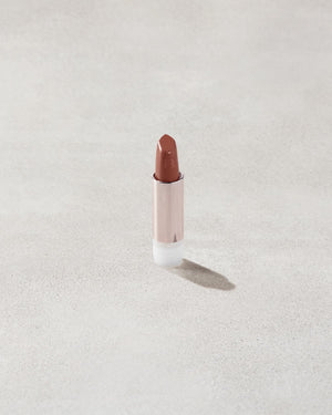 An open Fenty Icon refillable matte lipstick in the high-pigment shade, She a CEO.