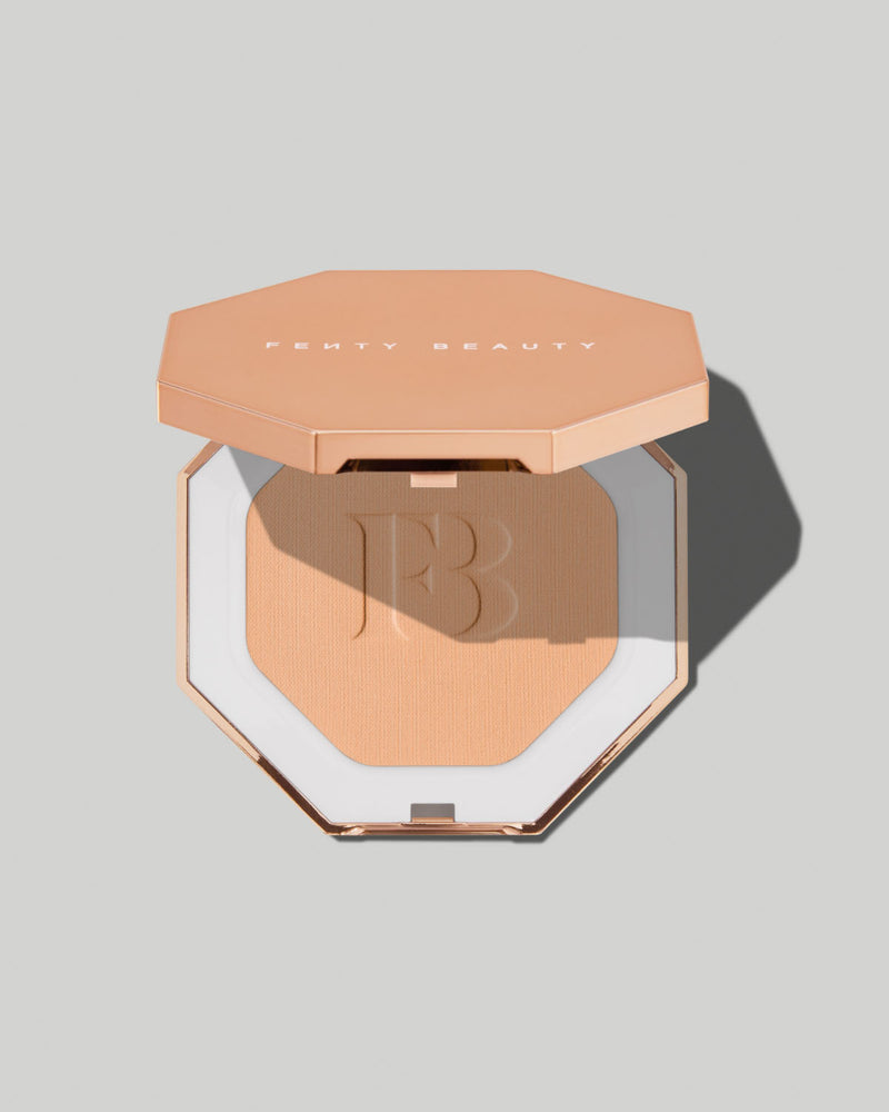 Fenty Beauty Pressed Powder in a square compact with a rose gold-coloured lid and rose gold trim, shown open against a solid gray background.