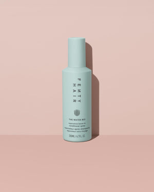 The Water Boi Reparative Leave-In Conditioner Spray on a peach background.