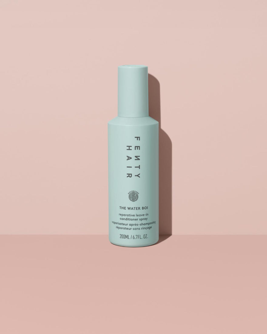 The Water Boi Reparative Leave-In Conditioner Spray on a peach background.