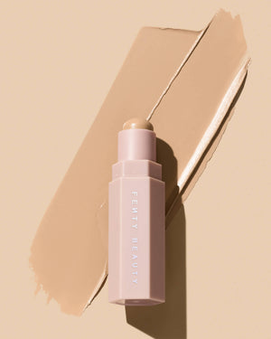 Match Stix Contour Skinstick shown in shade Soft Amber on a peach background with smear behind it.