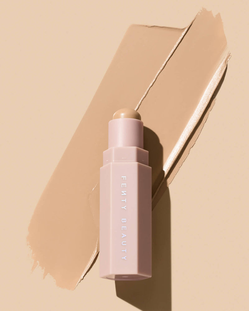 Match Stix Contour Skinstick shown in shade Soft Amber on a peach background with smear behind it.